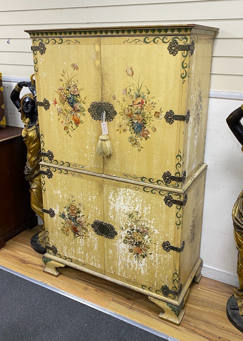 A decorative cream flower painted linen press cupboard, height 168cm, width 104cm, depth 51cm
